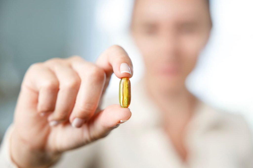woman holding a fish oil supplement