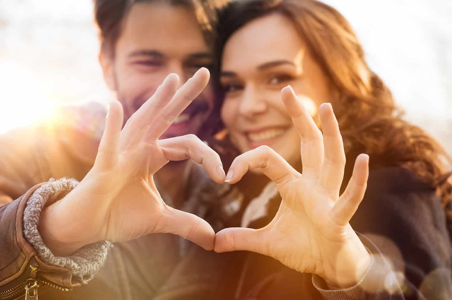 couple making a heart shape with fingers