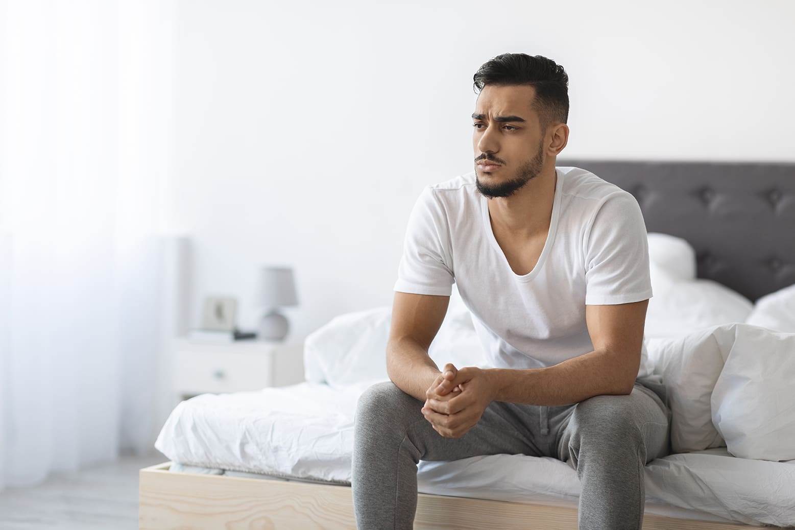 man sitting on his bed concerned about erectile dysfunction