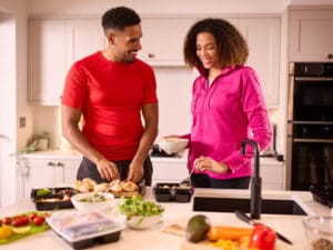 couple in kitchen preparing food to illustrate healthy protein intake