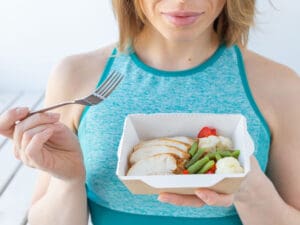 close-up of woman holding healthy food to illustrate the importance of protein in a balanced diet