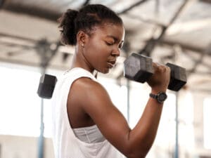 sporty woman with a dumbbell to illustrate body health benefits of protein