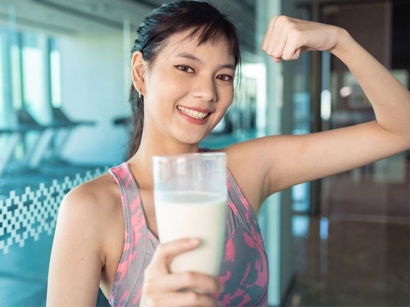 young woman with a glass of protein shake to illustrate best protein powder for women