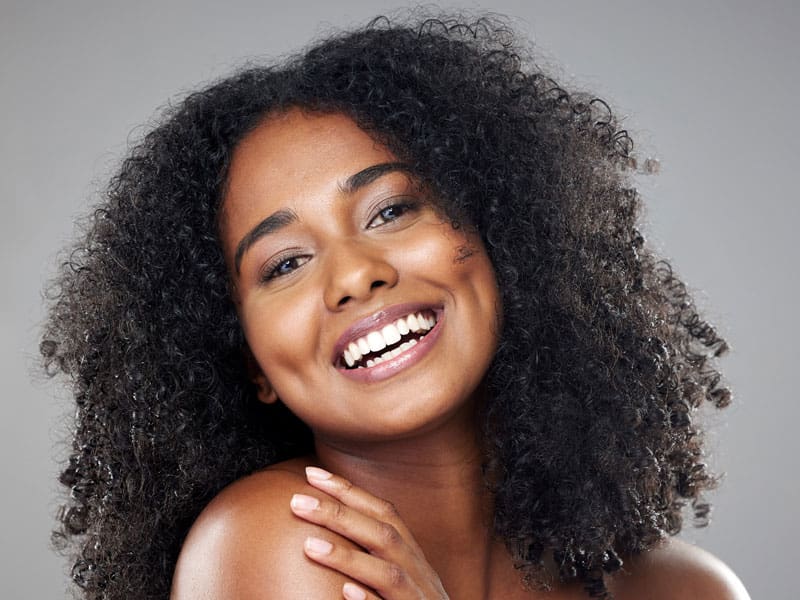 Black woman with glowing skin to illustrate the benefits of a VI Peel