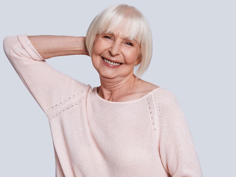 A happy older woman smiling to illustrate how to overcome the risks of inflammation and aging