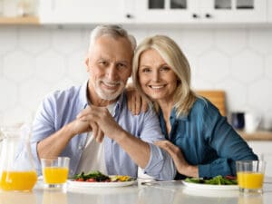 happy mature couple in the kitchen to illustrate how poor food choices can cause inflammation in older adults