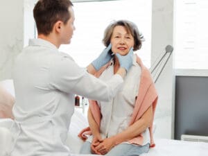 medical man examining a woman to assess problems