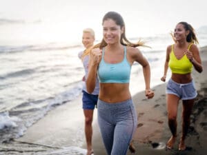 happy women running on the beach to illustrate good weight loss results