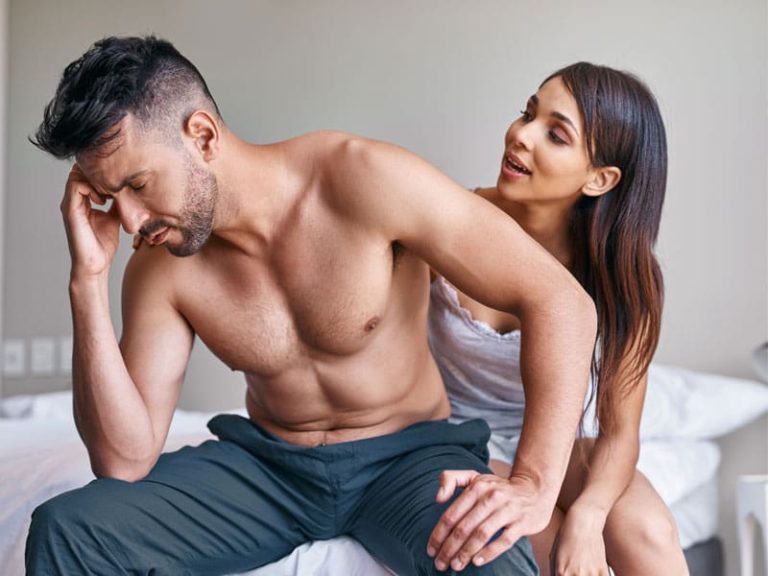 upset man sitting on bed ignoring partner, to illustrate the need to know about foods for erectile dysfunction