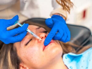 Doctor applying Botox to patient's lips to illustrate the use of Botox and fillers