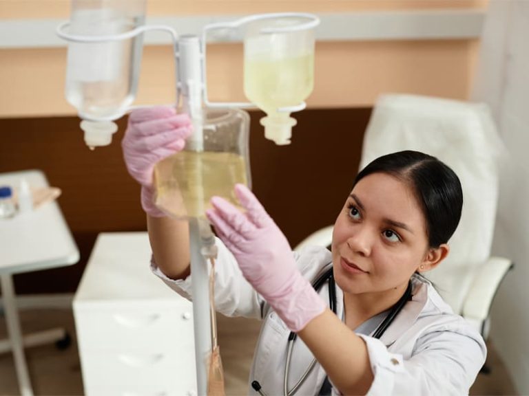 Nurse setting up equipment to illustrate glutathione IV therapy benefits